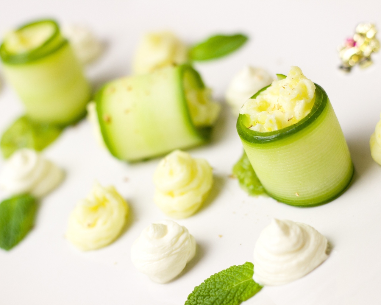 Рулетики из огурца с кремом на белом фоне