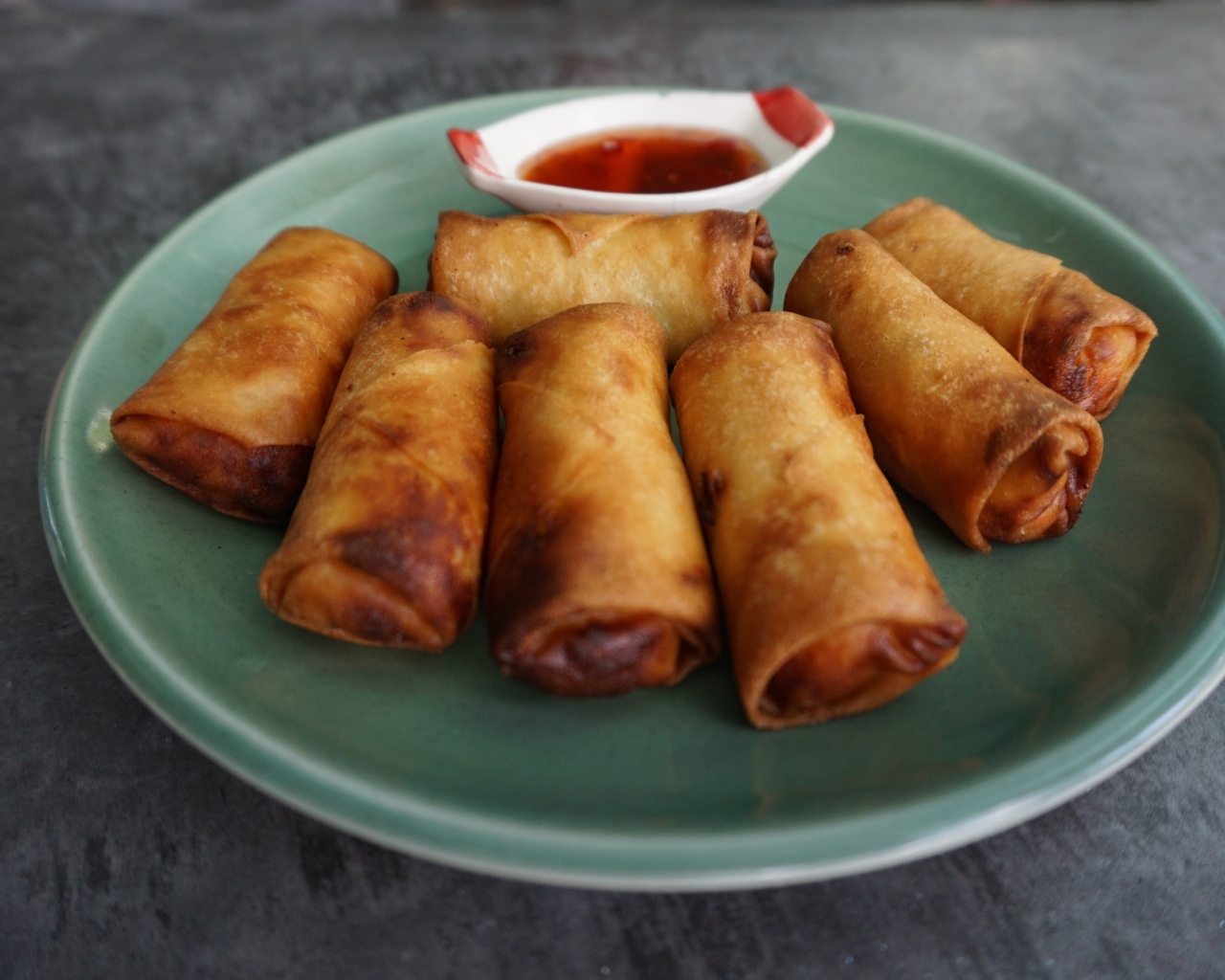 Яичные рулетики на большой тарелке с соусом