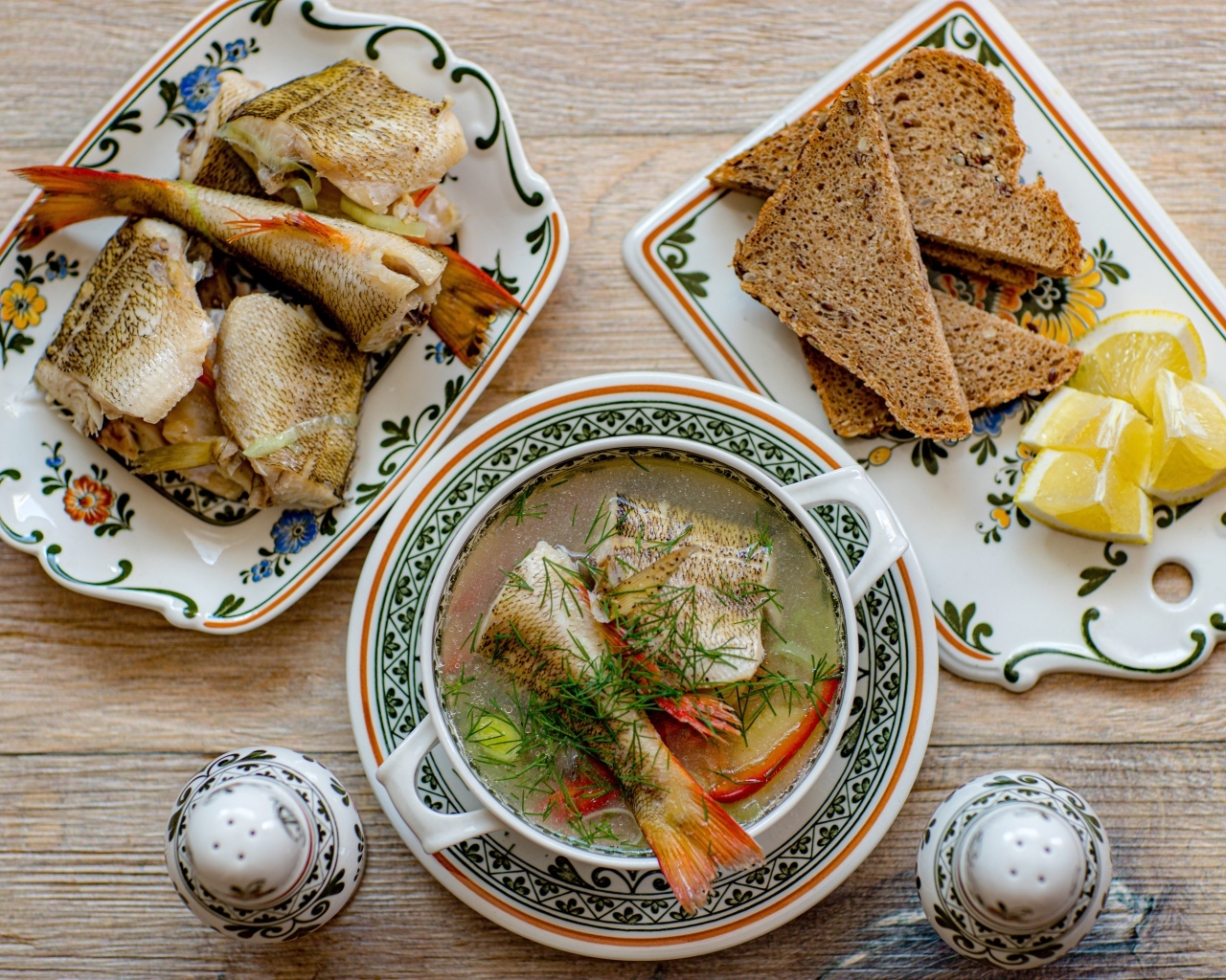 Уха на столе с хлебом и лимоном