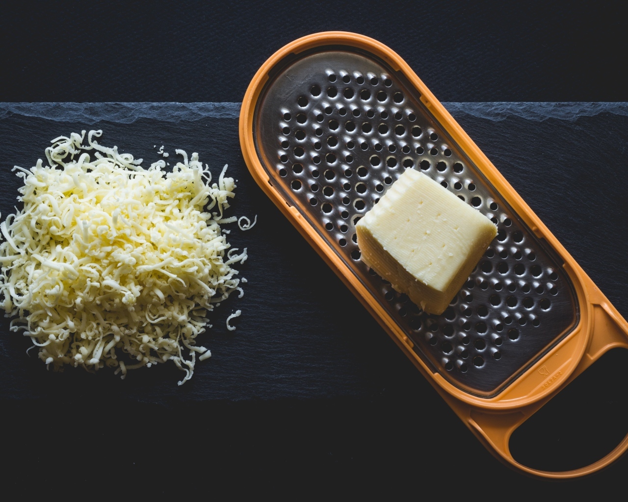 Тертый сыр на черном столе