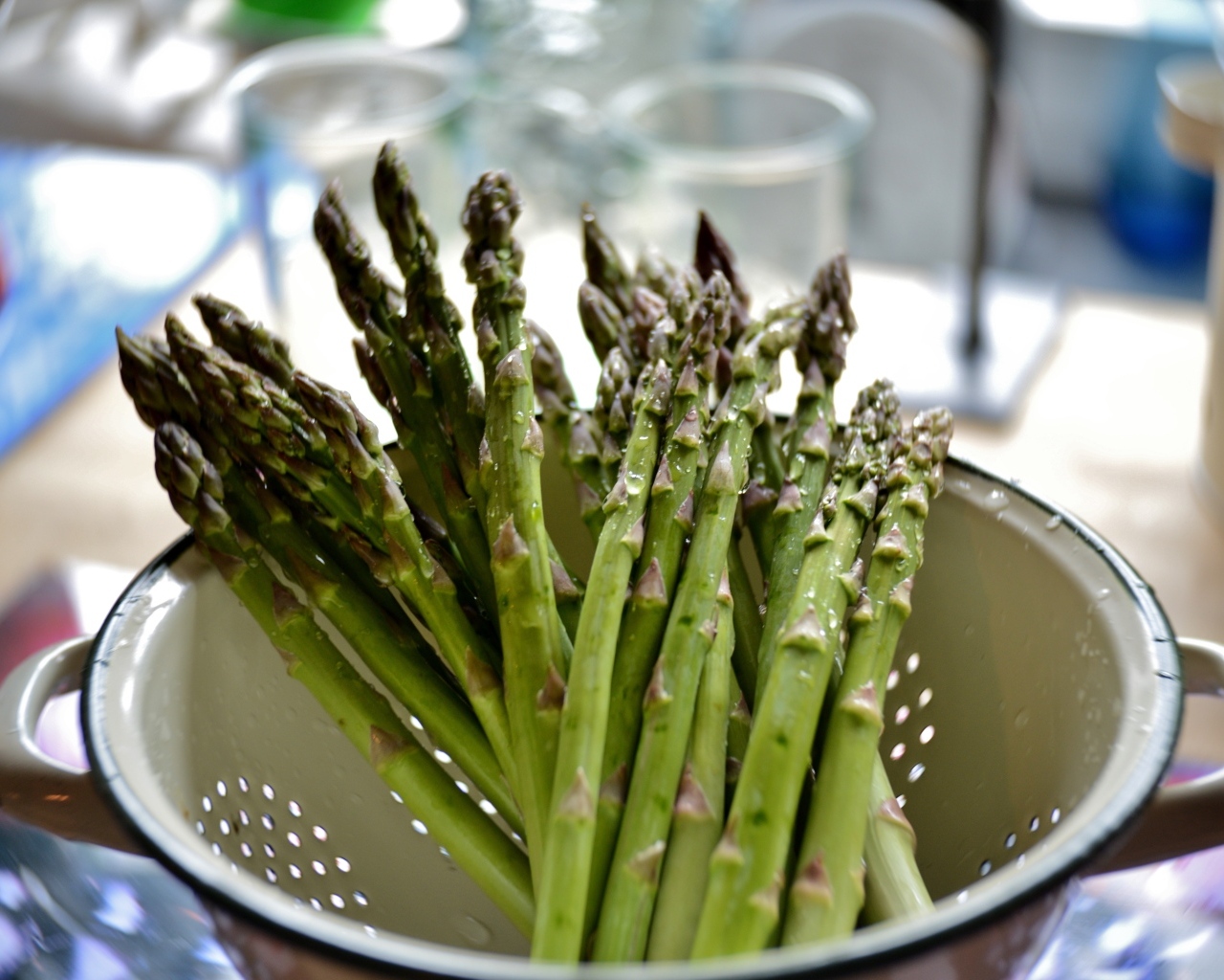 Зеленая спаржа в посуде на столе