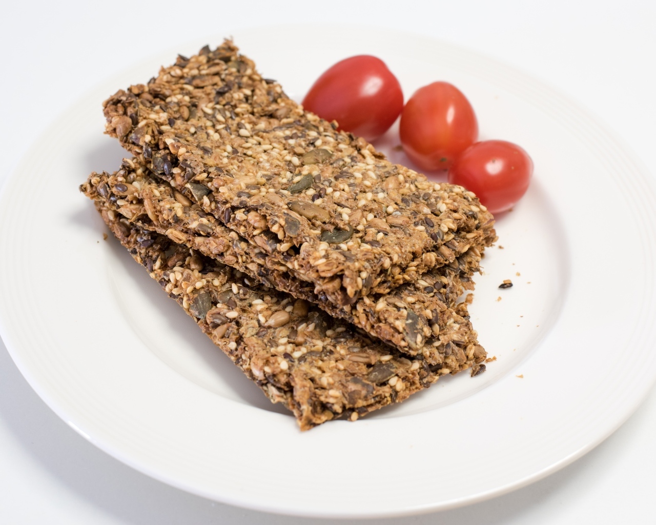 Полезны злаковые хлебцы на тарелке с помидорами