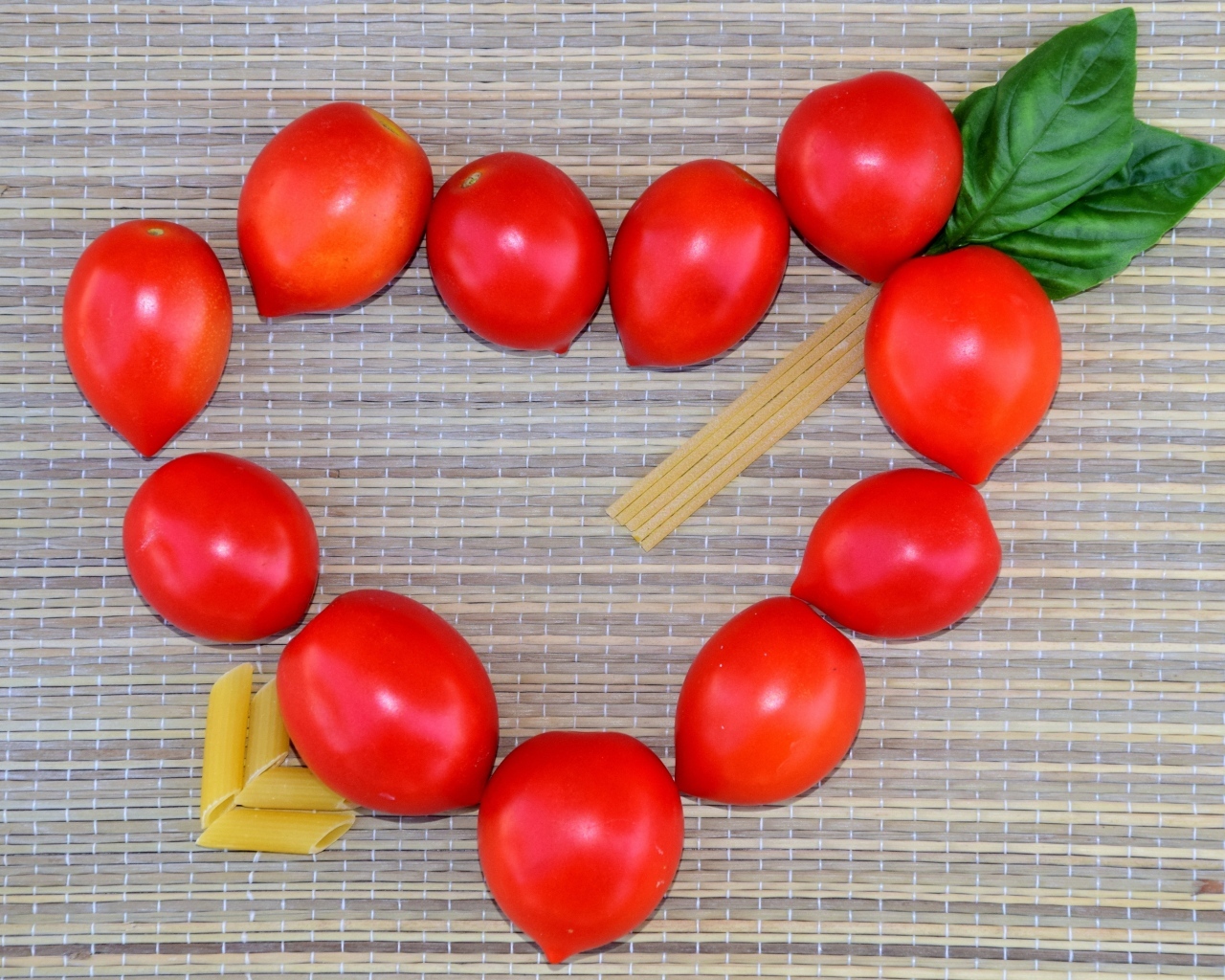 Сердце из помидоров на столе с макаронами