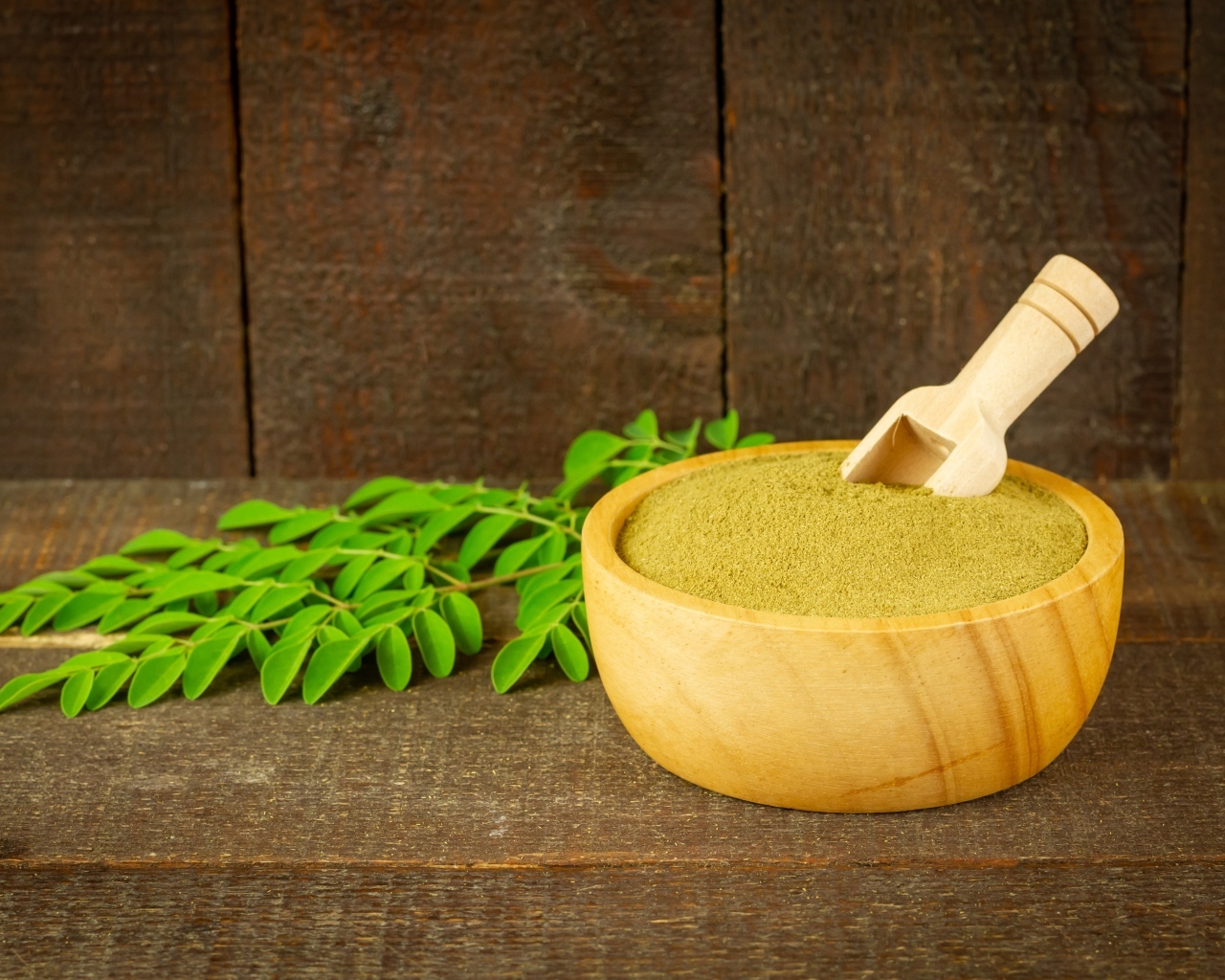 Порошок моринга на столе с листьями