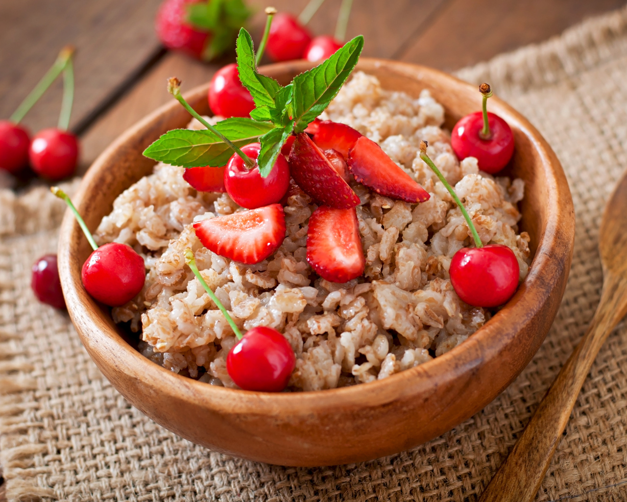 Овсяная каша с ягодами в деревянной миске