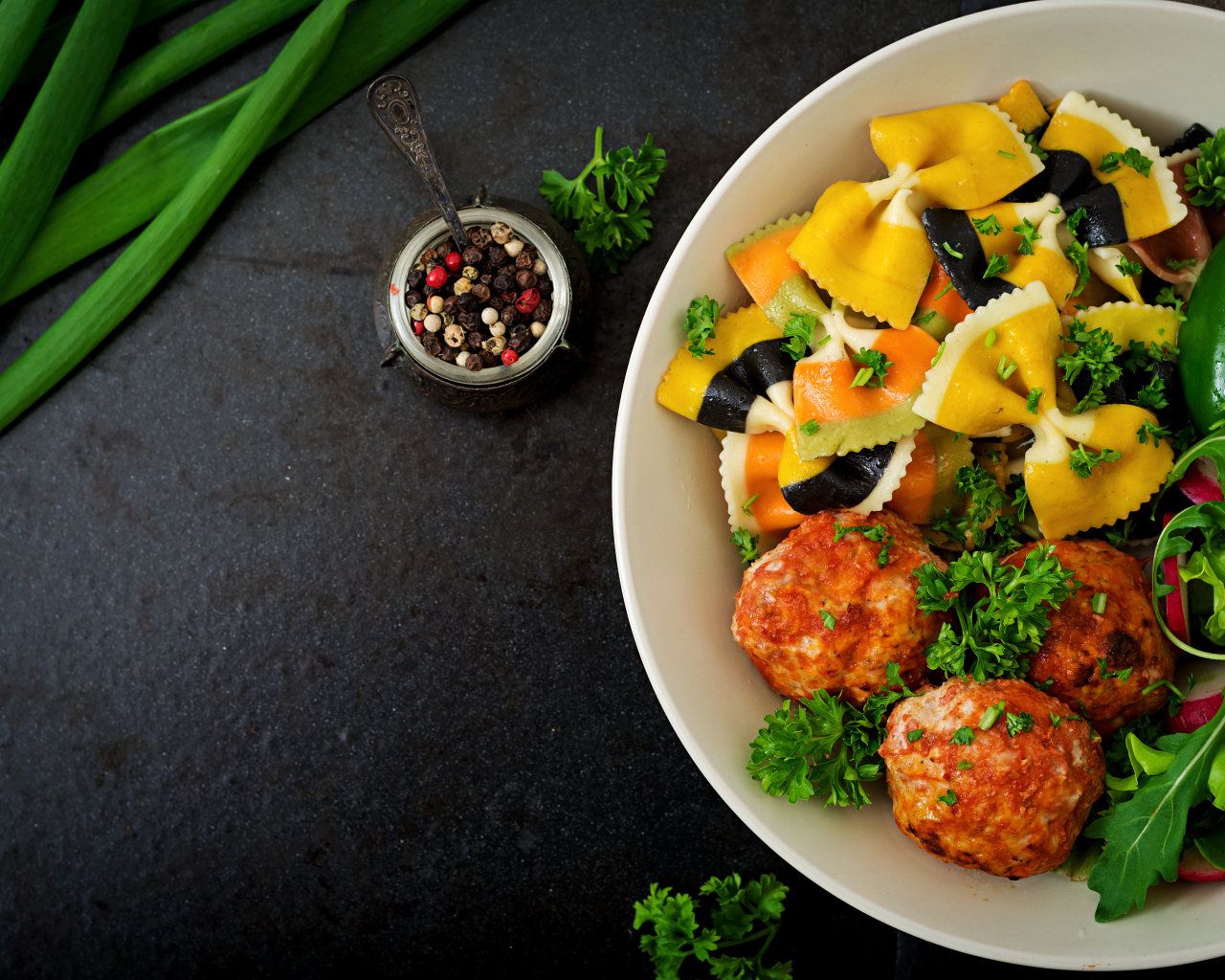 Паста с тефтелями и салатом в тарелке