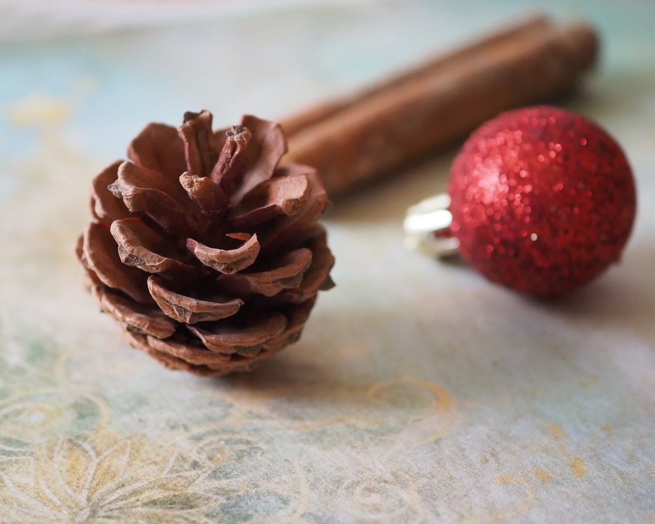 Шишка, шарик и корица на столе