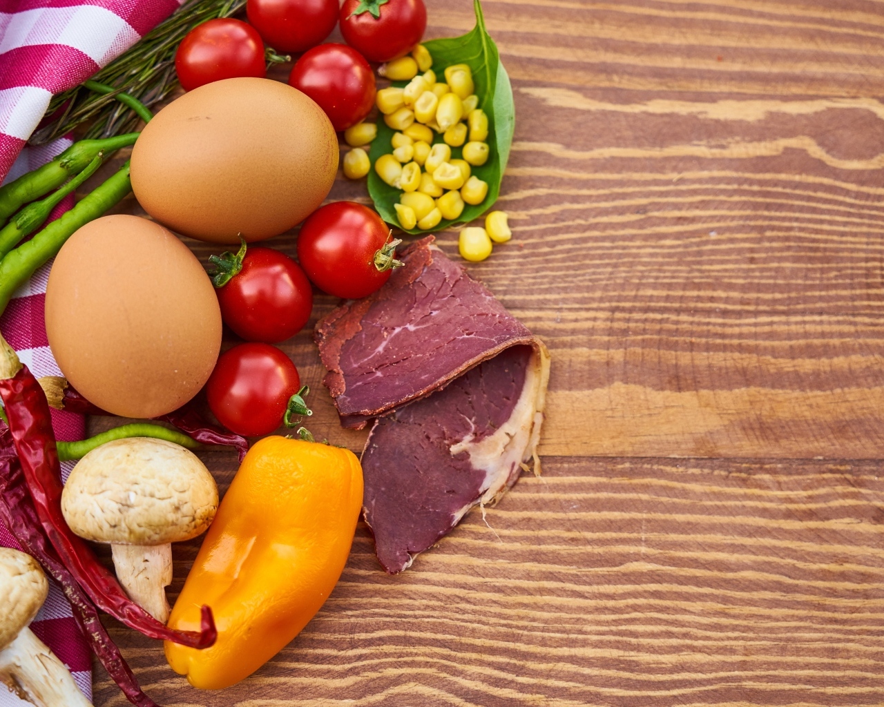 Продукты на деревянном столе с полотенцем