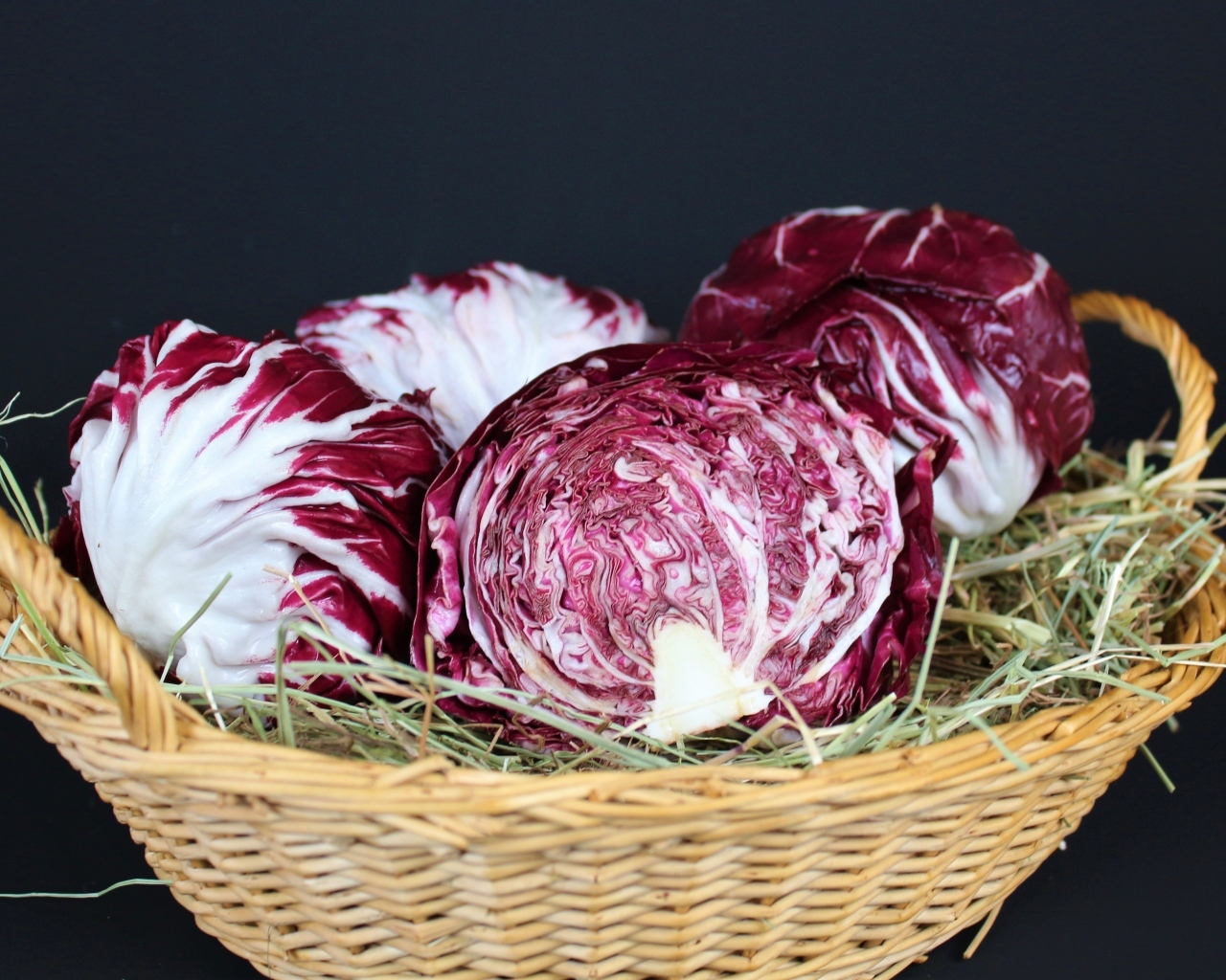 Красная капуста в корзине на черном фоне