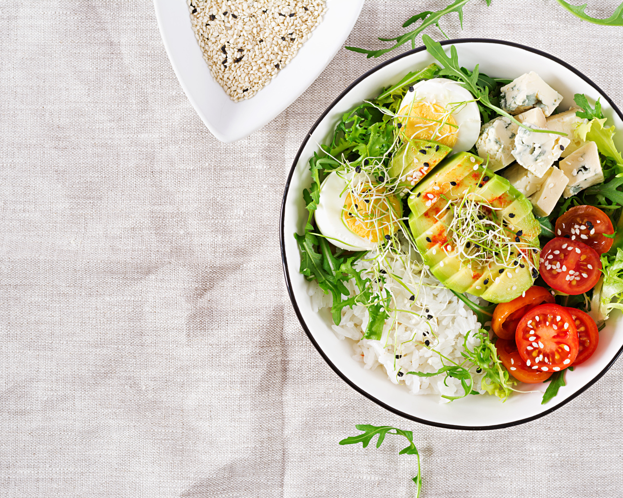 Рис с овощами и авокадо в тарелке