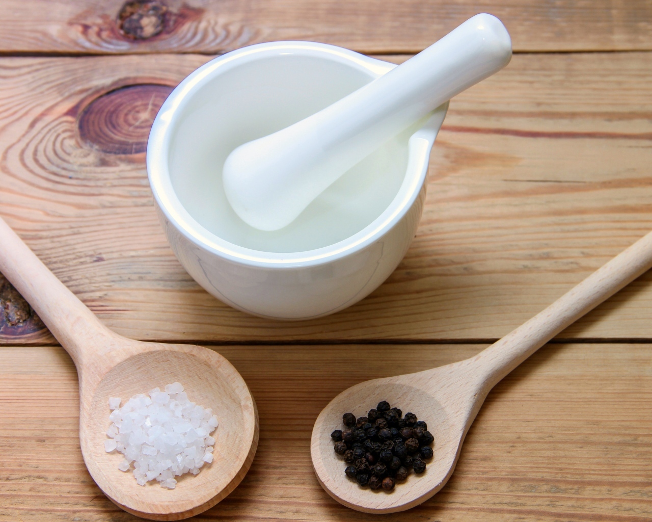 Соль с перцем на столе с деревянной ступкой