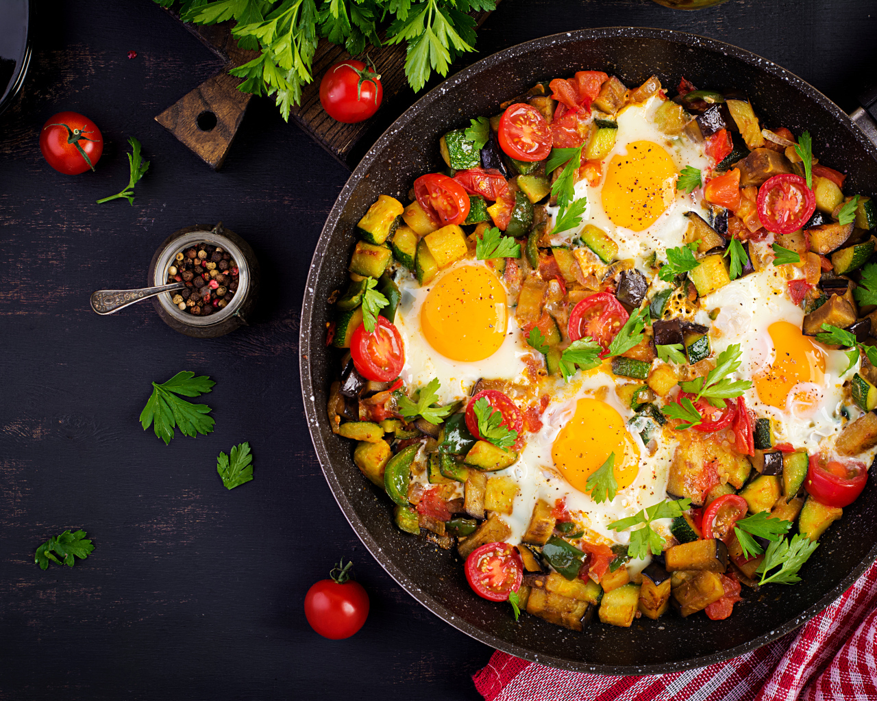 Яичница с овощами в сковороде на столе