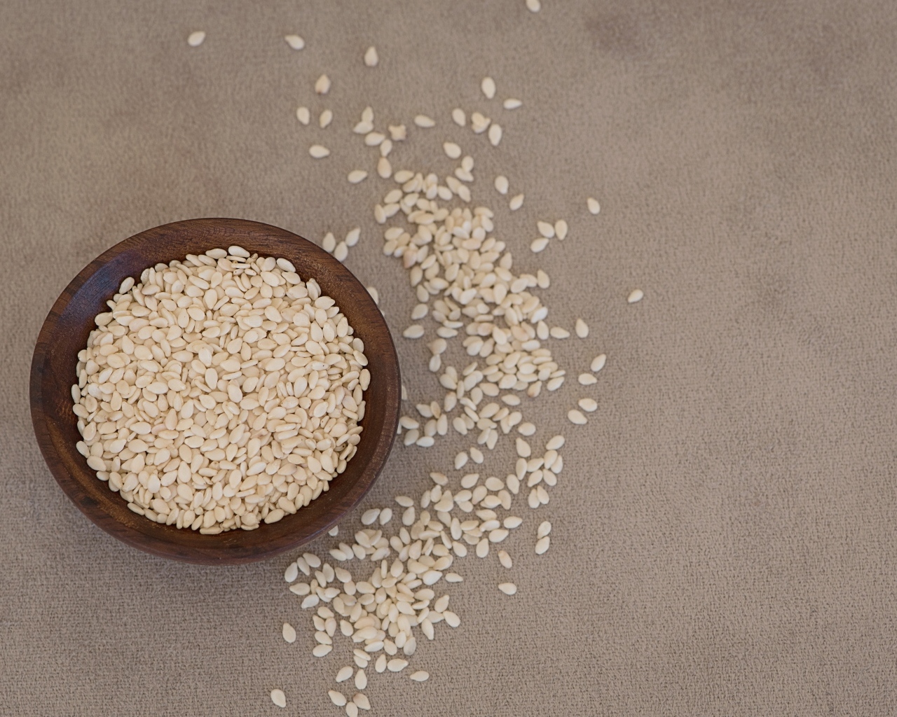 Зерна кунжута в деревянной миске на столе
