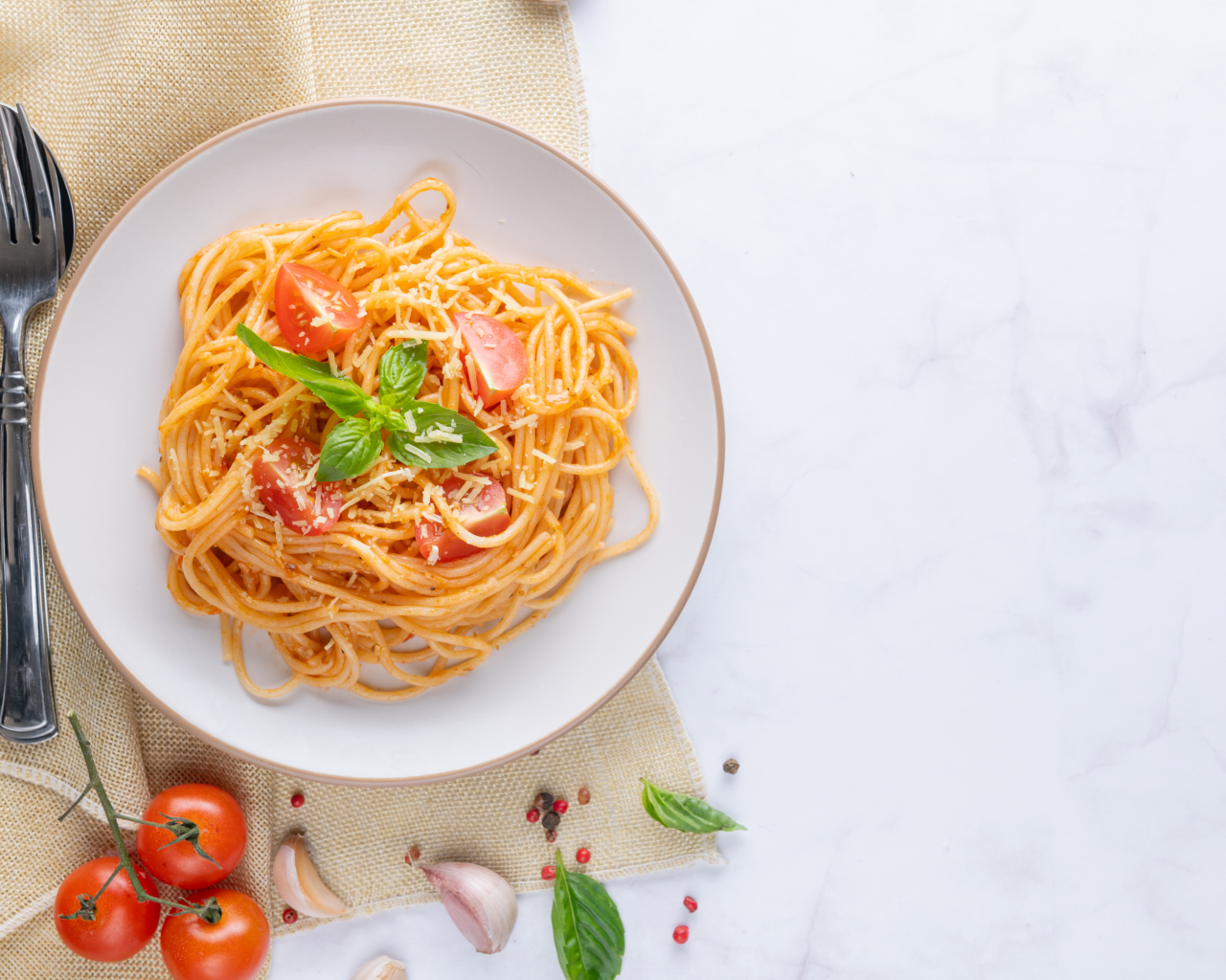 Спагетти с помидорами в тарелке на столе
