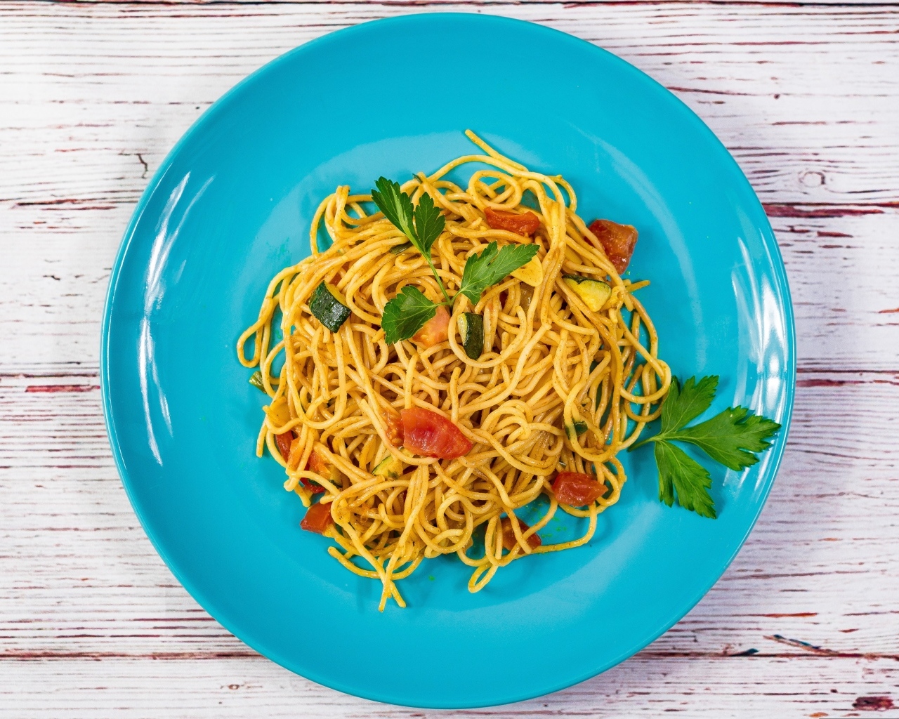 Спагетти с овощами  на голубой тарелке