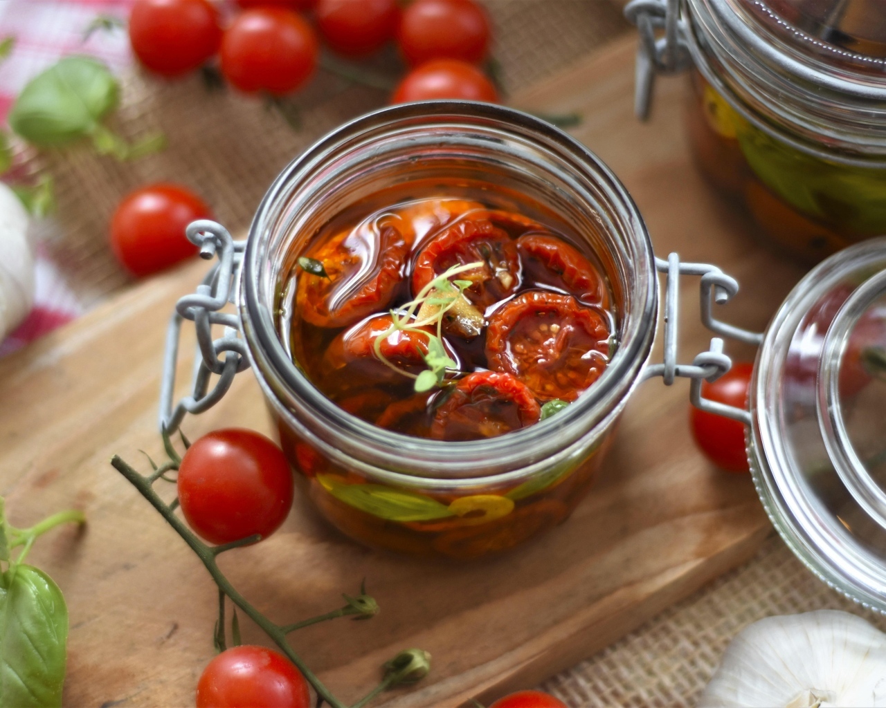 Вяленые томаты в масле в стеклянной банке на столе