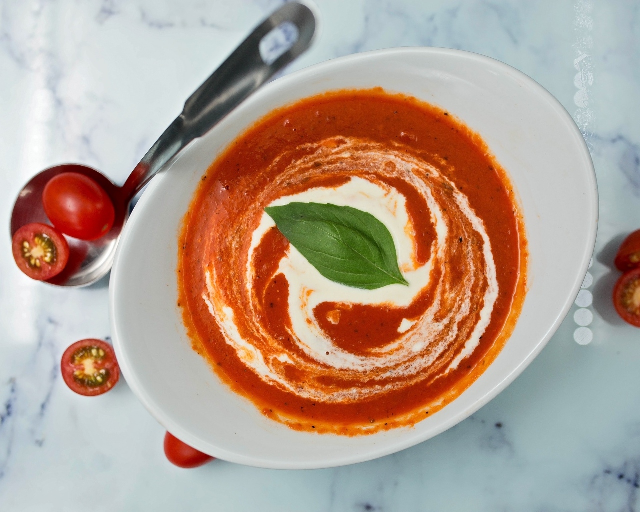 Томатный суп со сметаной в белой тарелке