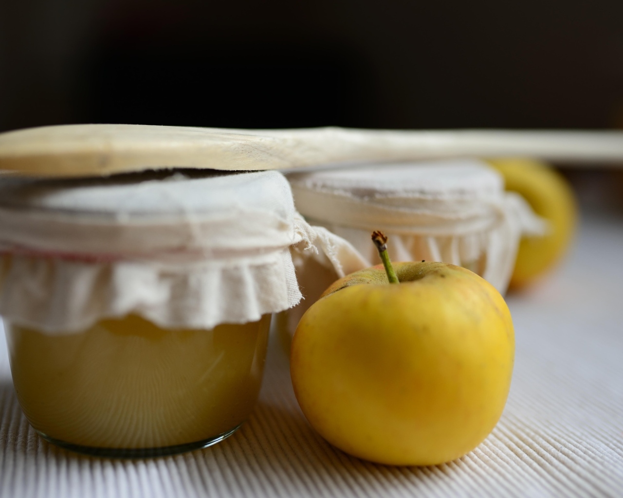 Яблочное пюре в банке на столе с плодами