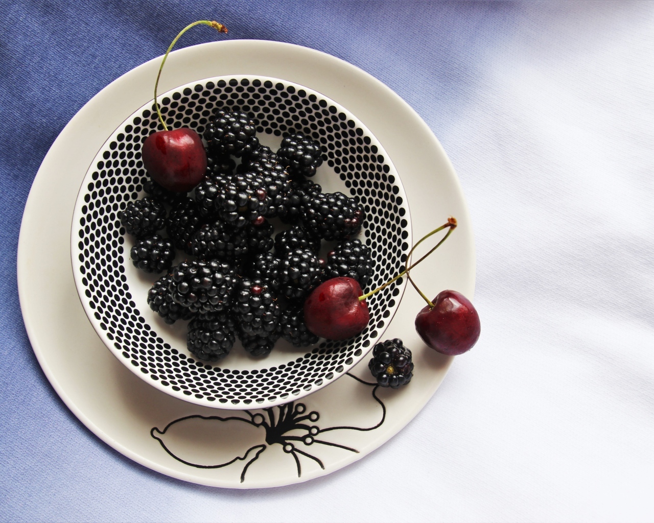 Ягоды ежевики и черешни на столе