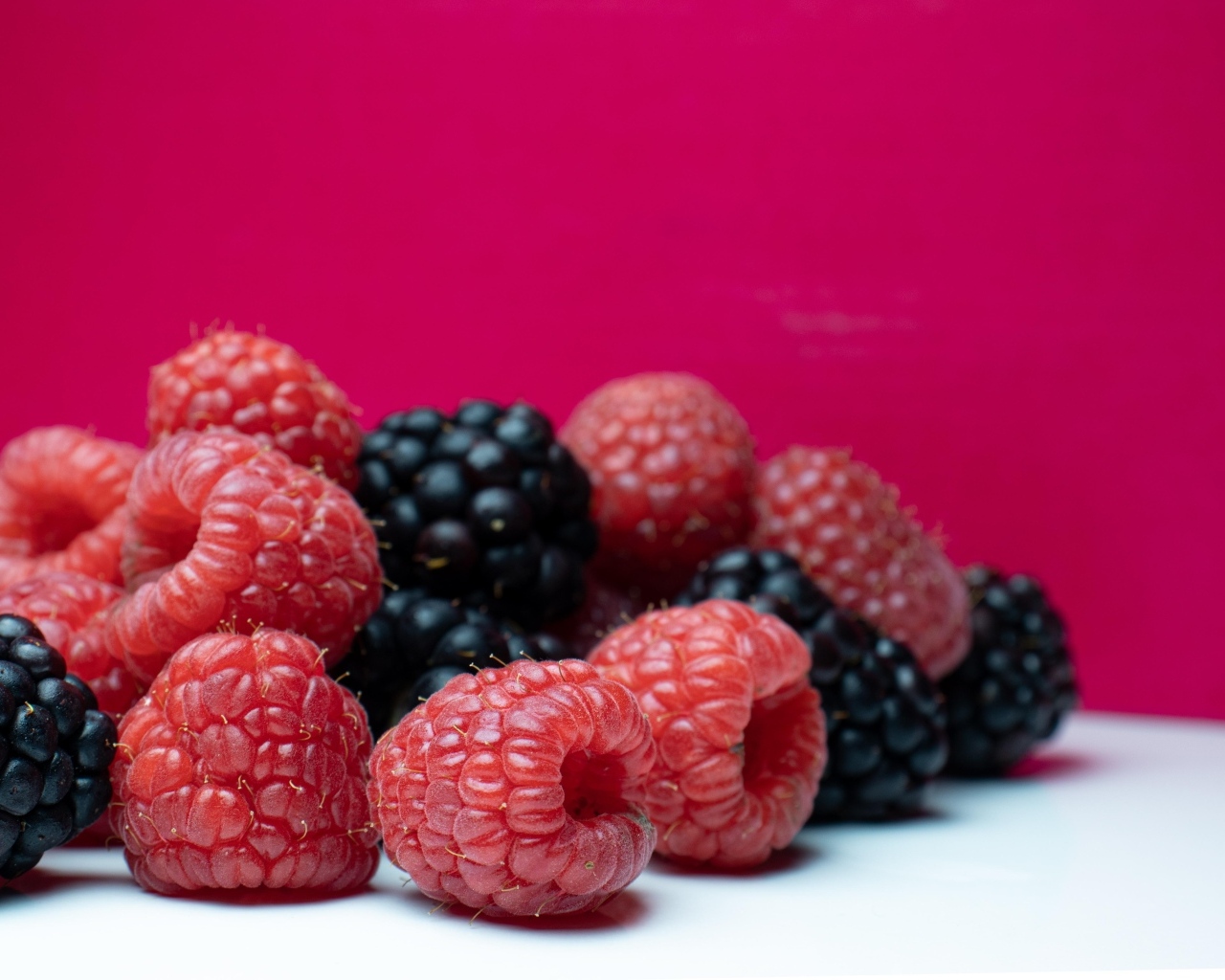 Ягоды черники и малины на красном фоне