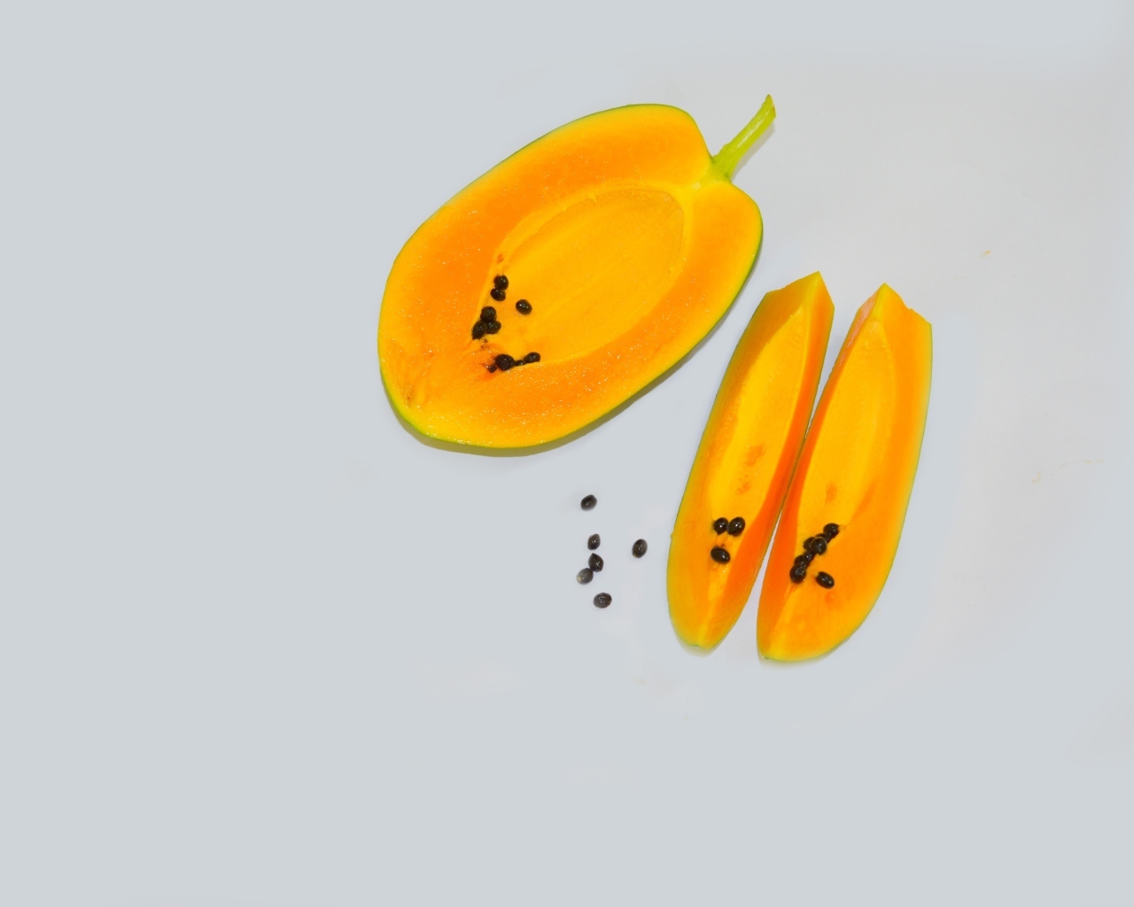Разрезанная папайя на сером фоне