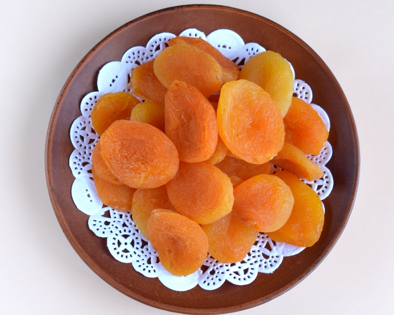 Курага с тарелке на сером фоне