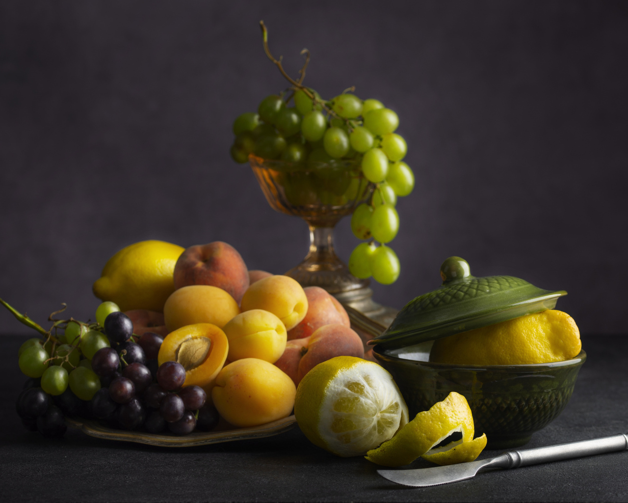 Свежие фрукты и ягоды на столе с ножом