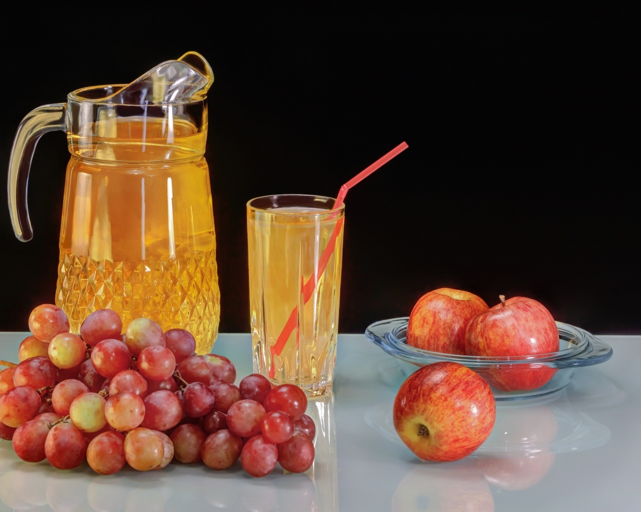 Виноград и яблоки на столе с соком