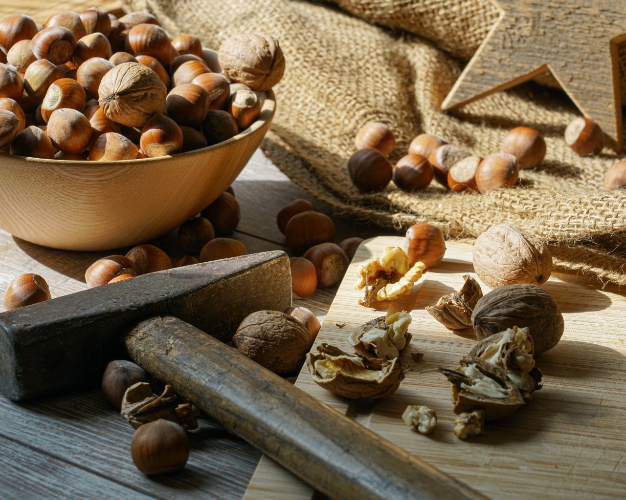 Фундук и грецкие орехи на столе с молотком