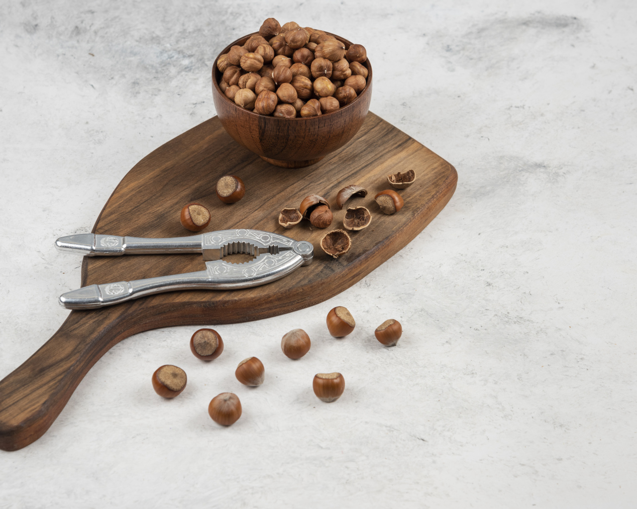 Лесные орехи на сером столе с разделочной доской