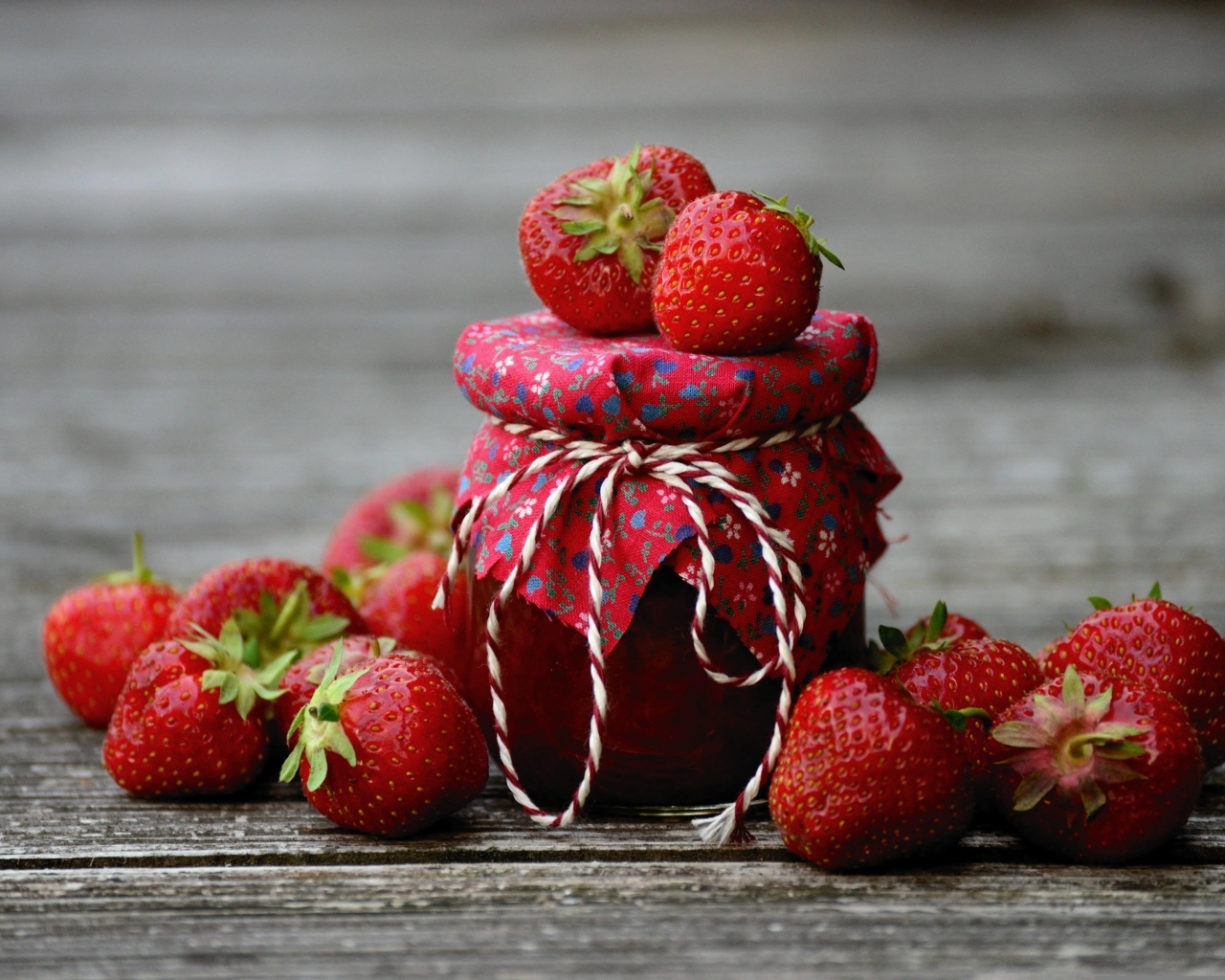 Банка джема на столе со свежими ароматными ягодами клубники