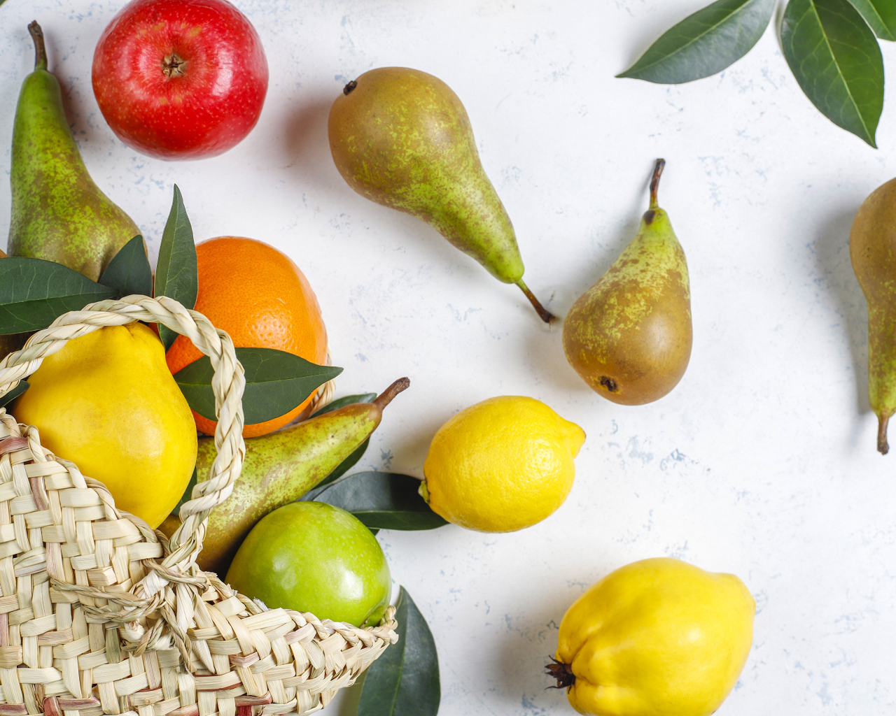 Груши, яблоки и апельсины с сумкой на столе