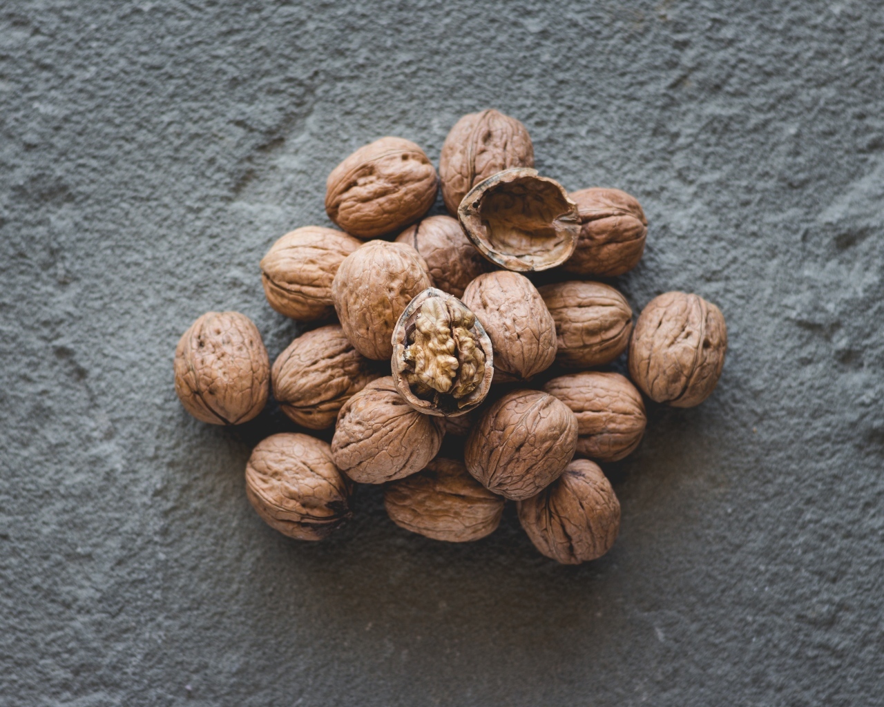 Куча грецких орехов на сером столе