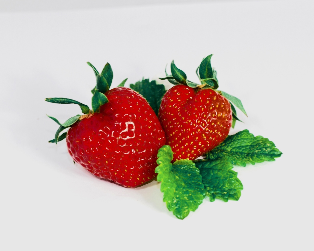 Красная клубника с листьями мяты на сером фоне