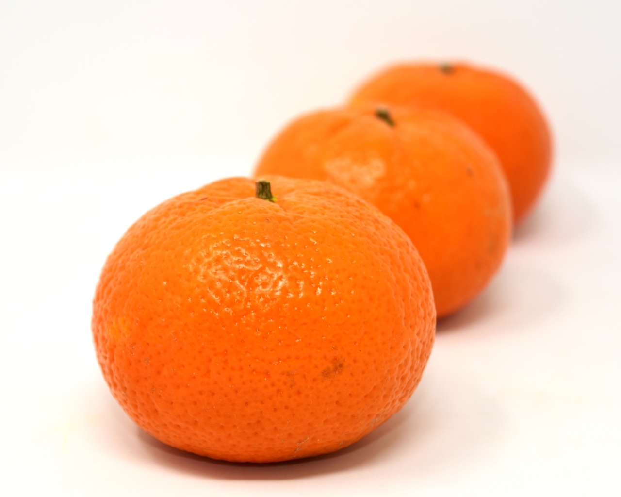 Три больших спелых мандарина на столе