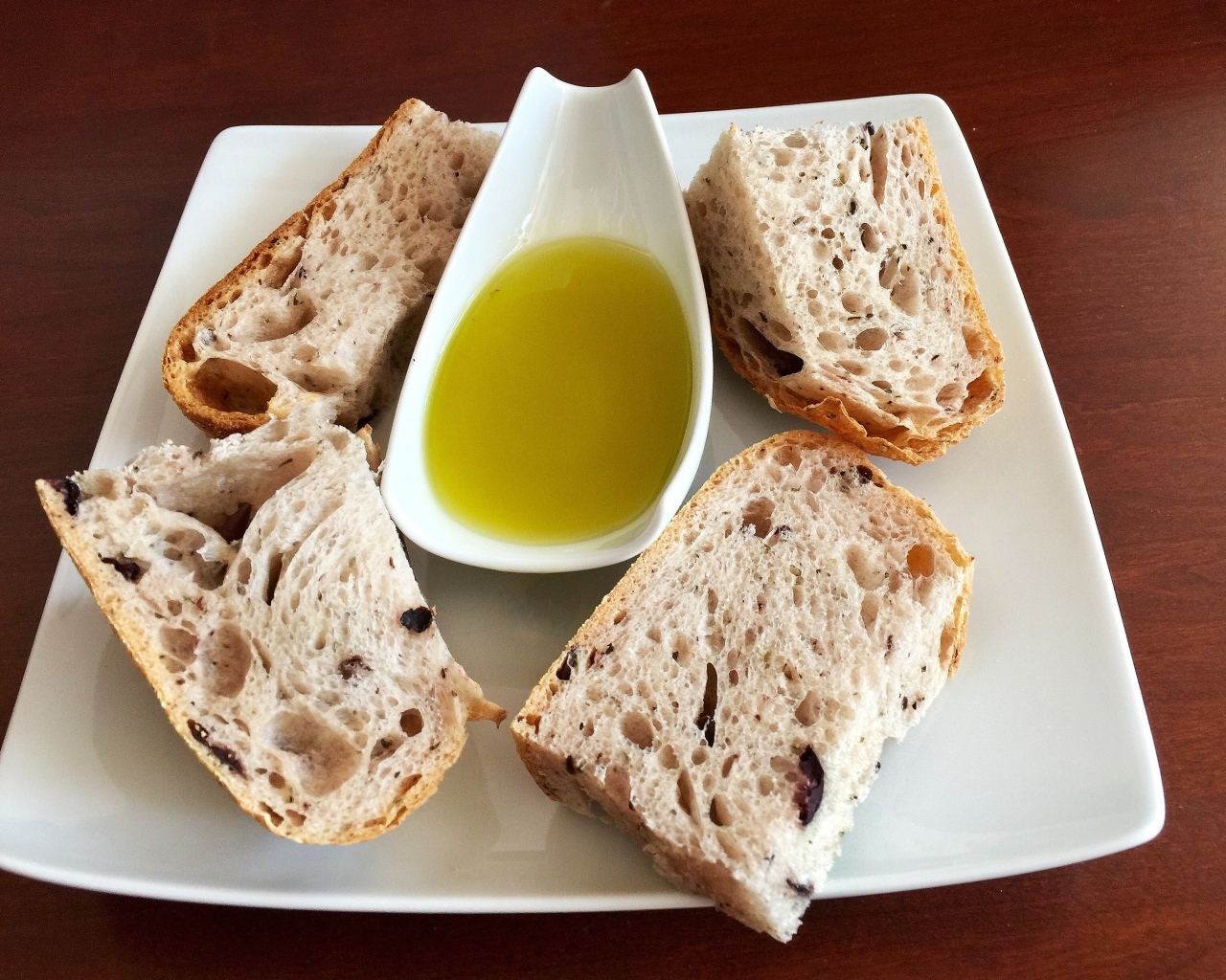 Свежий ароматный хлеб с оливковым  маслом на тарелке