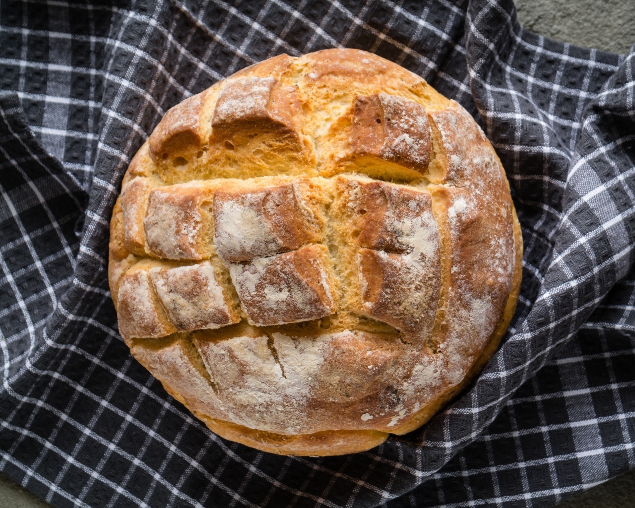 Круглый хрустящий хлеб на столе со скатертью