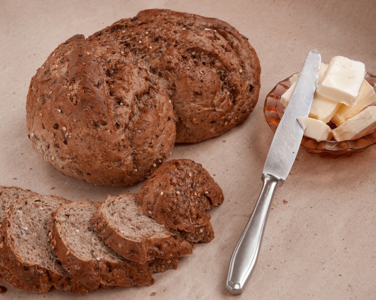 Ржаной хлеб со сливочным маслом и ножом на столе