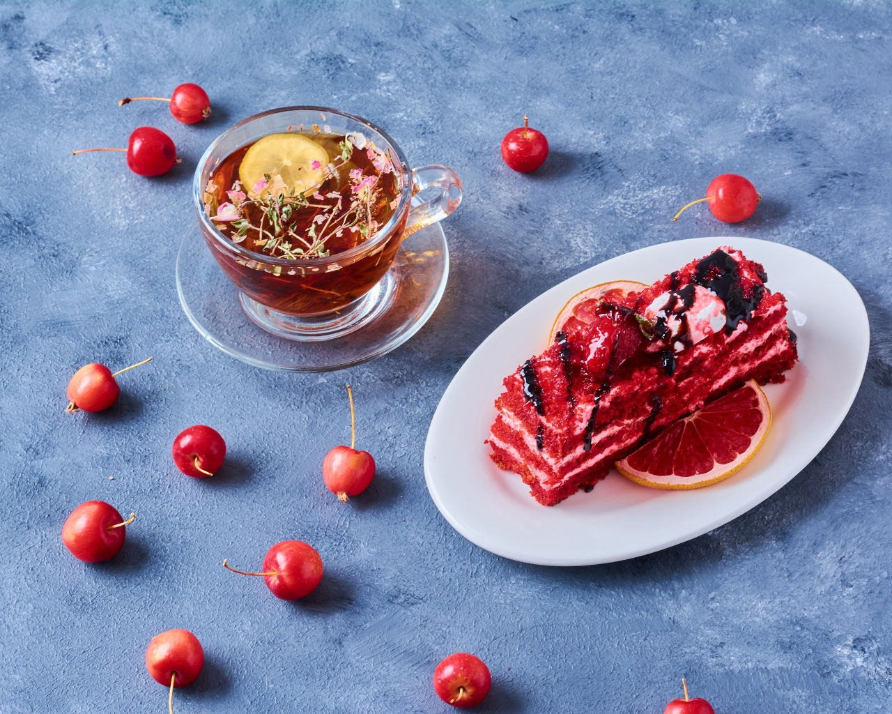 Аппетитный кусок торта на столе с чаем и ягодами черешни