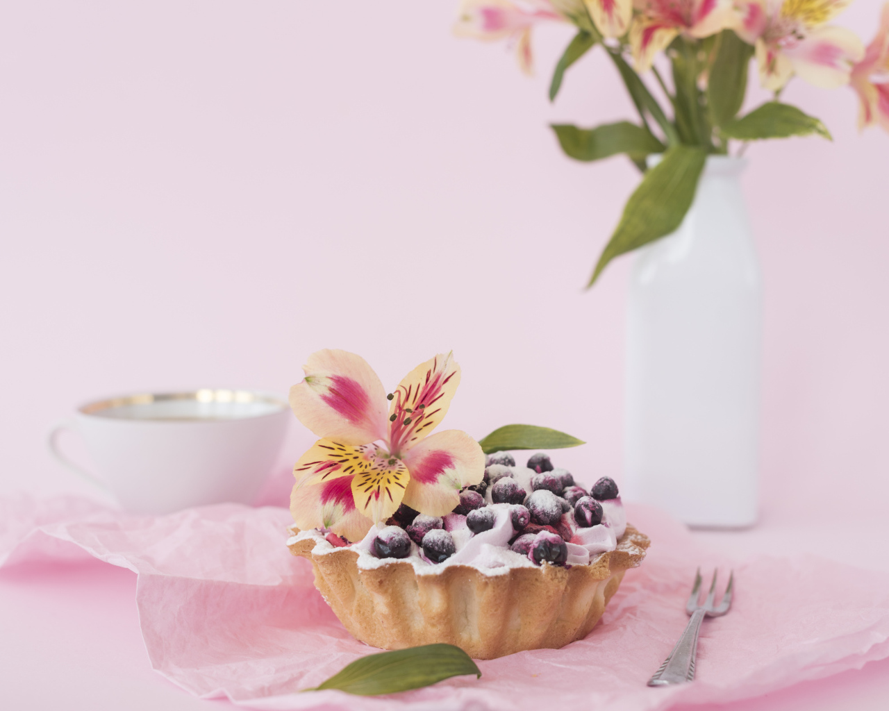 Черничное пирожное с цветами альстромерии на розовом фоне
