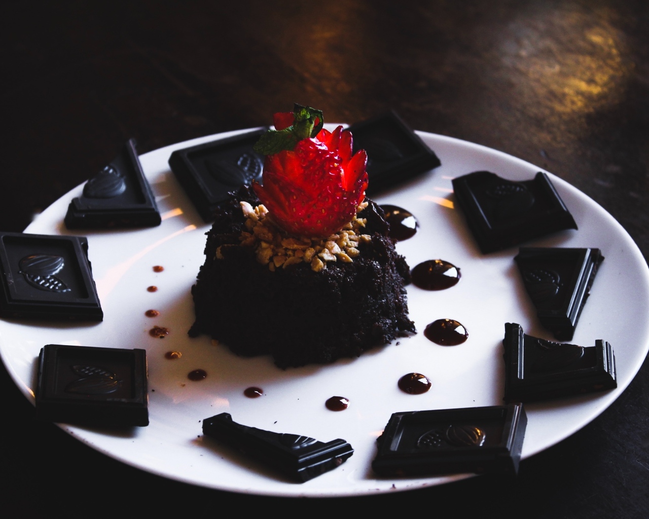 Десерт брауни на большой белой тарелке с шоколадом