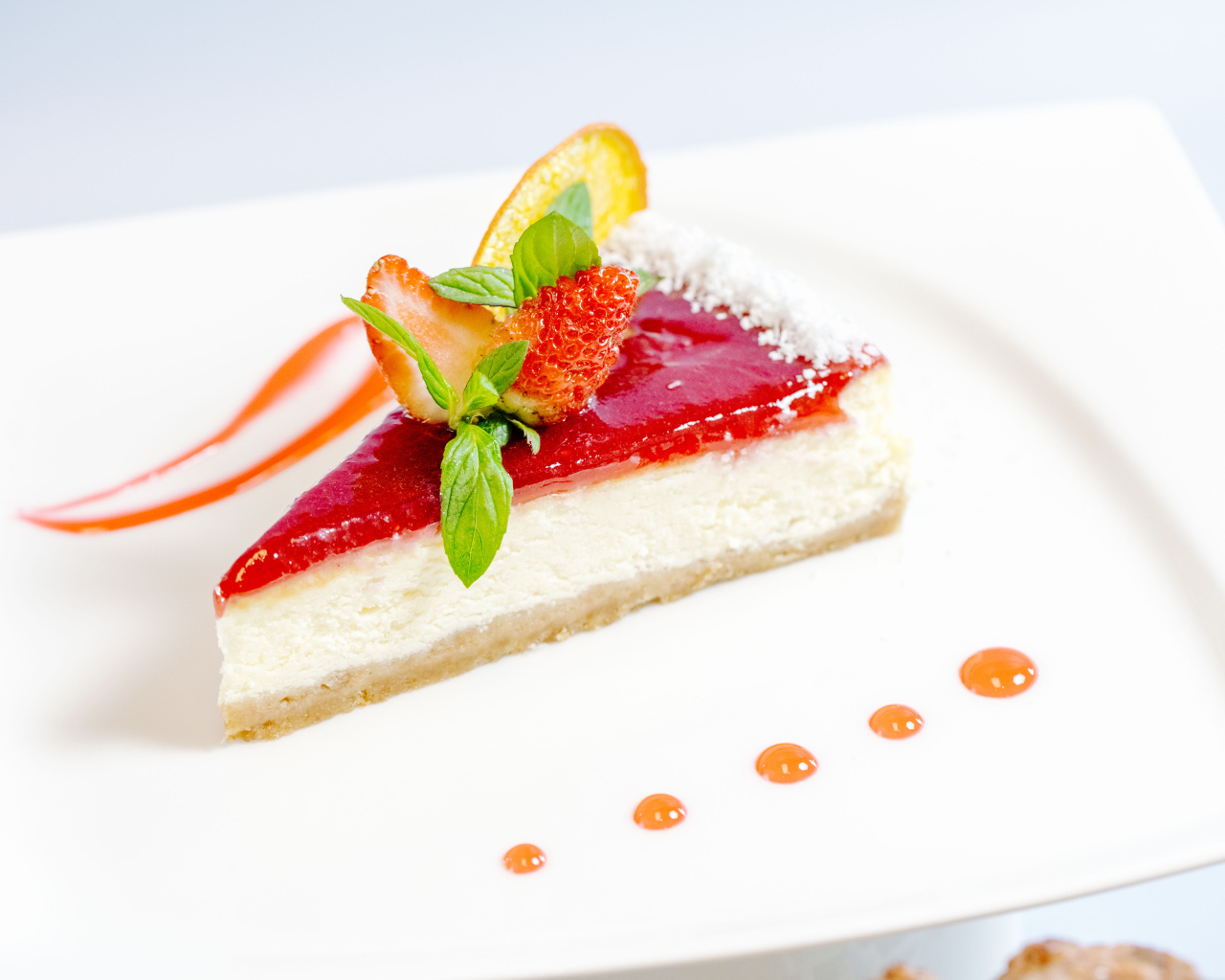 Чизкейк с клубничным джемом и ягодами на белой тарелке