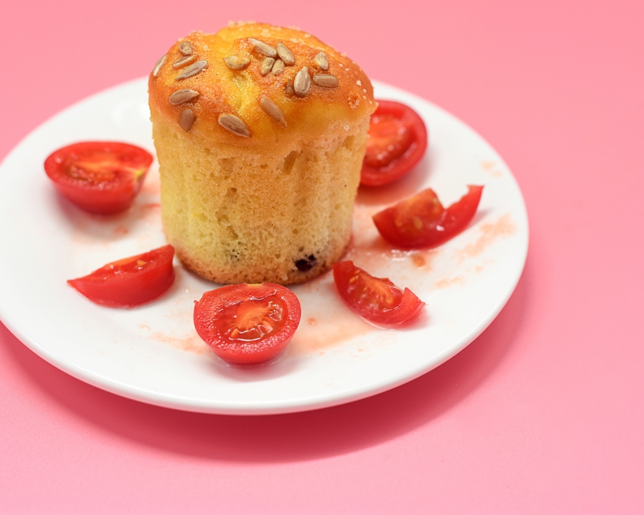 Кекс с помидорами черри на белой тарелке