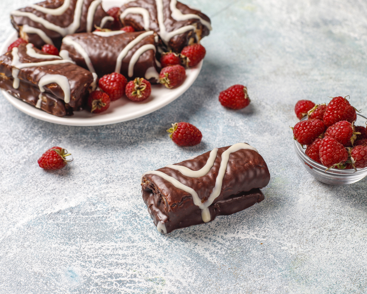 Шоколадные рулетики с ягодами малины на столе