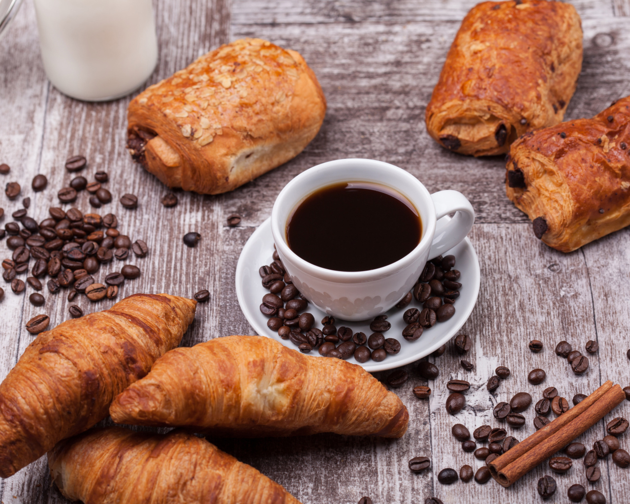 Кофе на столе с круассанами и зернами