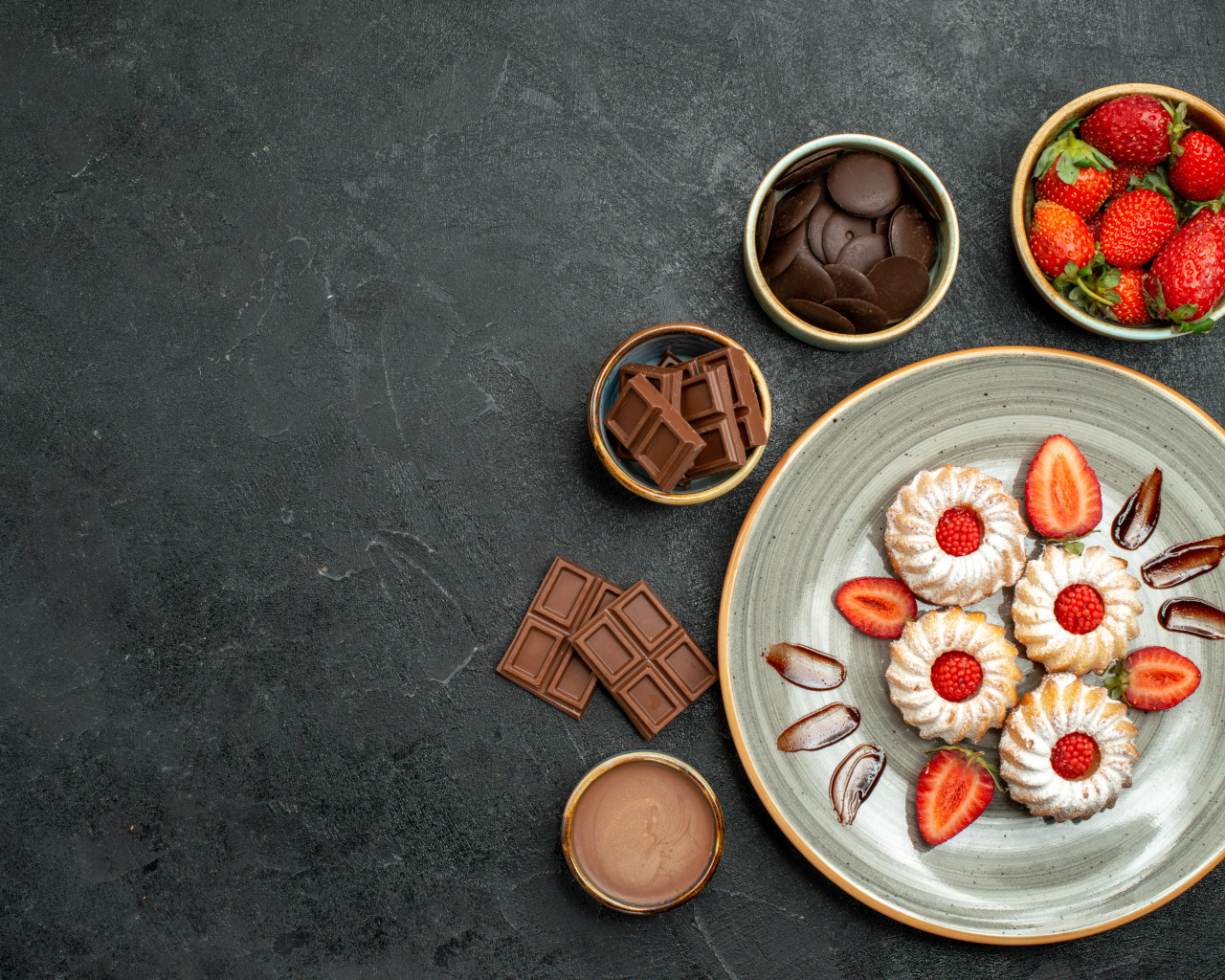 Печенье на столе с шоколадом и ягодами клубники