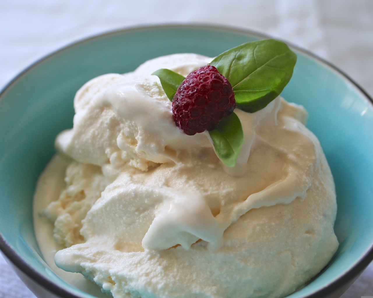 Сливочное мороженое в тарелке с ягодой малины