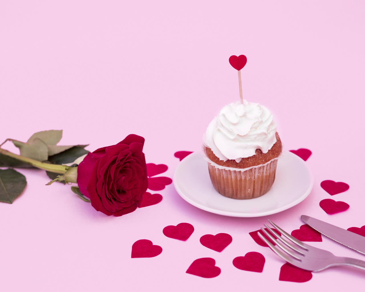 Кекс с красной розой и сердечками на розовом фоне