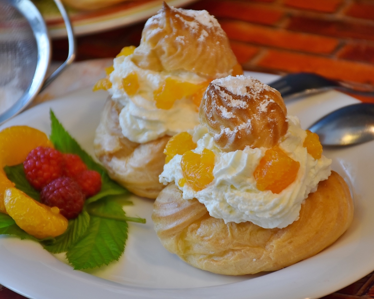 Заварное печенье со взбитыми сливками на тарелке с ягодами