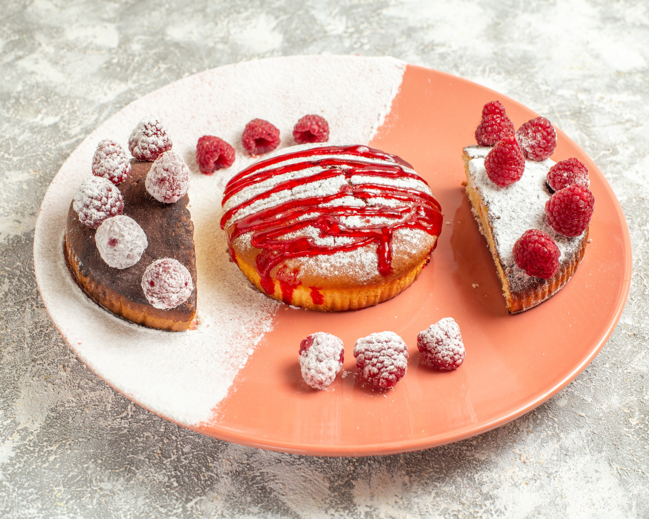 Десерт с ягодами малины и сахарной пудрой на большой тарелке